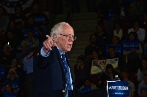 U.S.Senator and Presidential Candidate, Bernard Sanders speaks to a capacity crowd at UMASS Amherst. Sanders is at a lecture, dressed in a navy suit, a light blue shirt and matching blue tie. he is pointing to the right. Photo: Tracey C. O'Neill